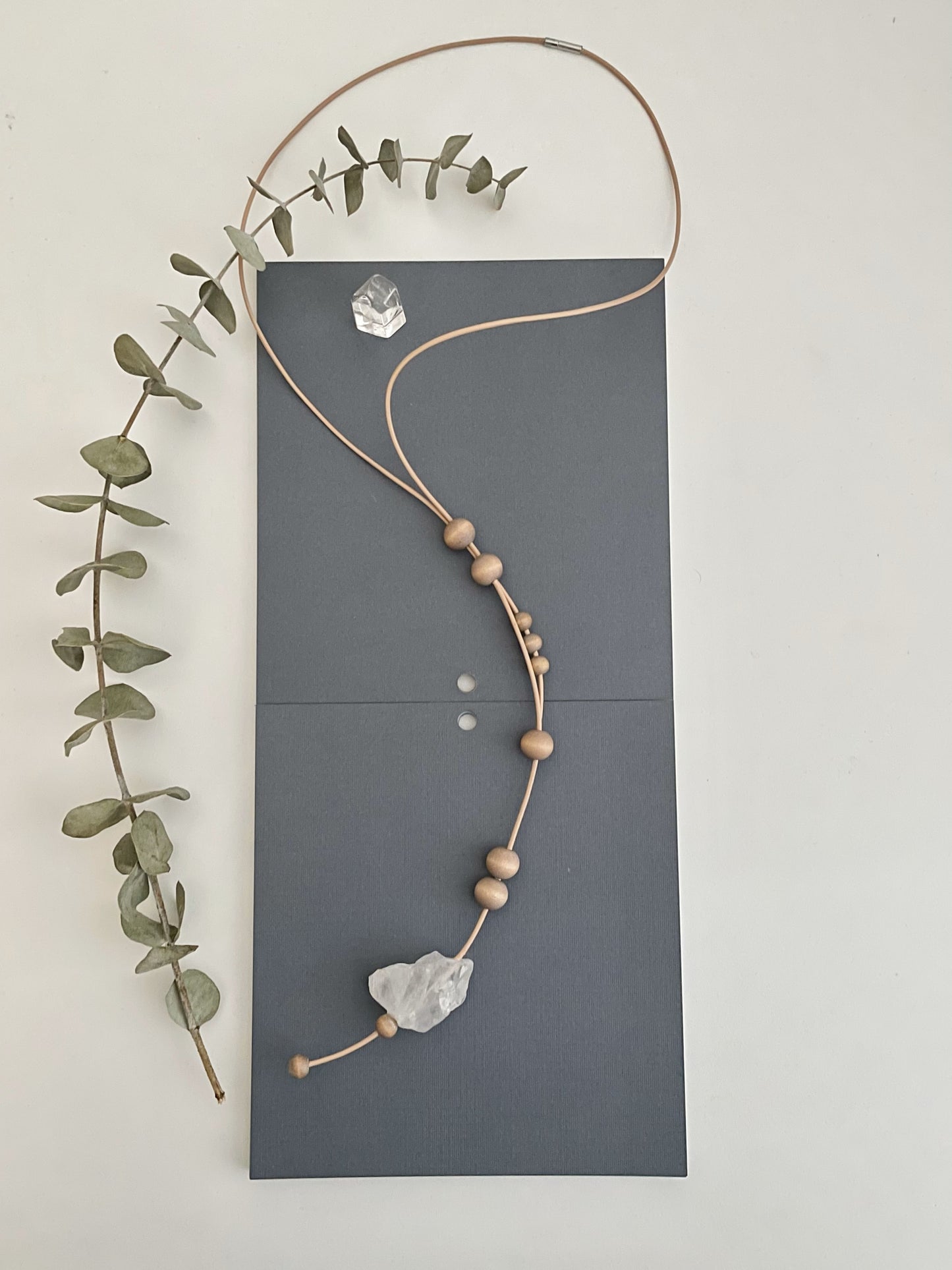 Unique minimalistic necklace inspired by the night sky along with quartz crystal, wood, leather cord, and a bayonet clasp